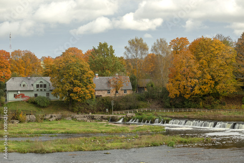 Autumn landscape with Trees with yellow-orange leaves on the banks of the Venta River and a waterfall. Kuldiga, Latvia. High quality photo photo