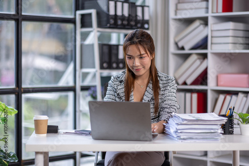 Young asian attractive businesswoman working on her project with laptop computer in modern office room. business plan investment, finance analysis concept.