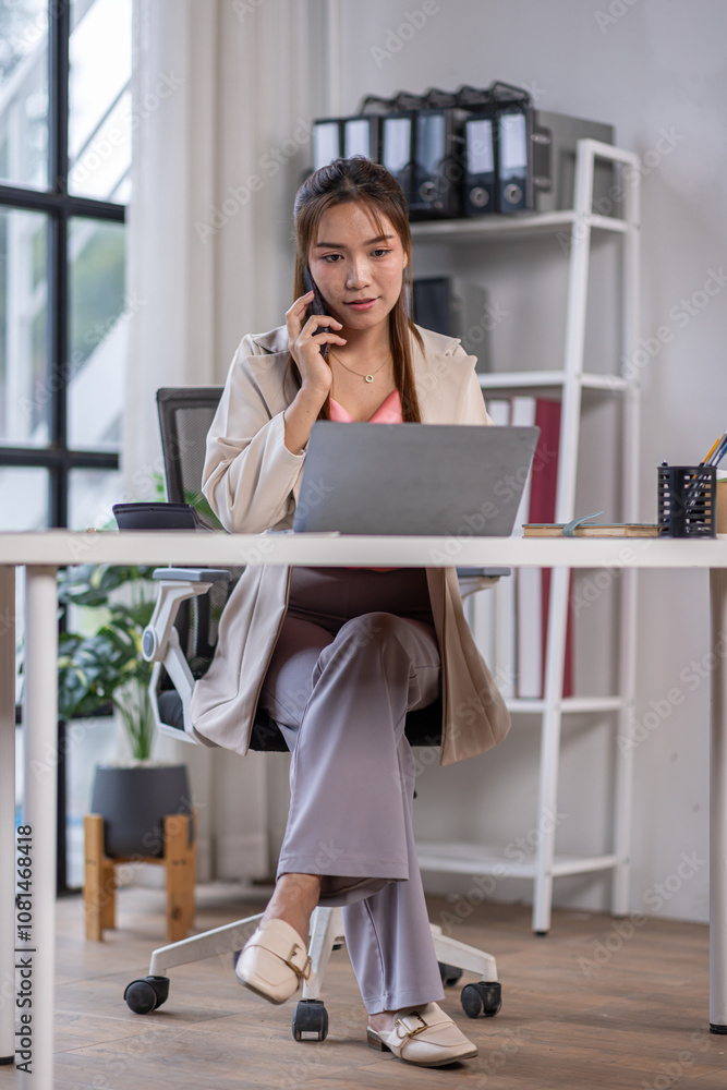 Fototapeta premium Attractive and professional millennial business Asian woman freelancer making telephone call share good news about project working in office workplace, business finance concept.