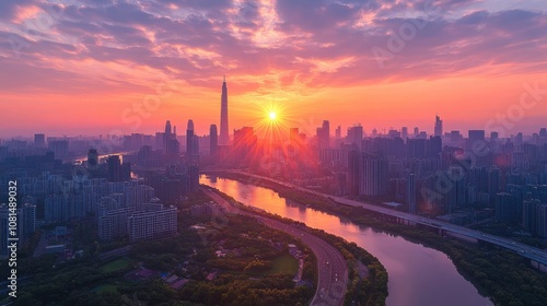 A vibrant sunrise paints the sky over a modern city skyline, with a river snaking through the cityscape.