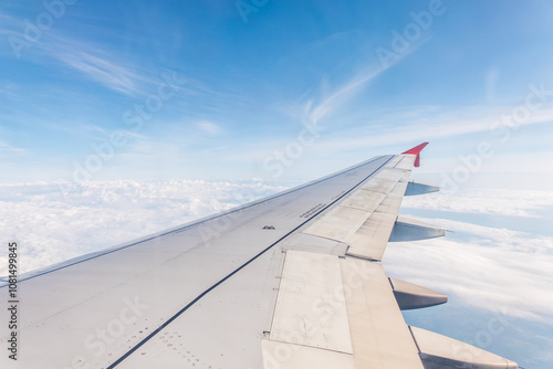 View from the airplane window at a beautiful cloudy sky and the airplane wing