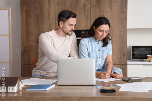 Young couple in debt writin...