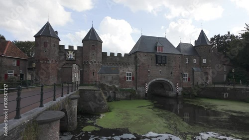 Koppelpoort gate with stone arches and water reflections in Amersfoort, Netherlands, daytime view, establishing pan photo