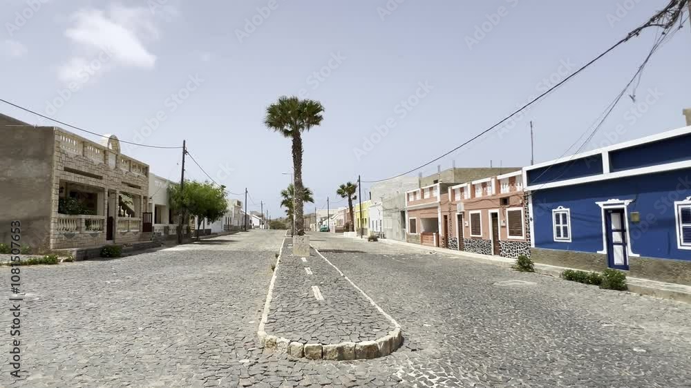 Peaceful street in Povoação Velha, Boa Vista, Cape Verde, with colorful buildings, palm trees, and cobblestone pavement. Captures the charm of this historic Cape Verdean village Peaceful street in Povoação Velha, Boa Vista, Cape Verde, with colorful buildings, palm trees, and cobblestone pavement. Captures the charm of this historic Cape Verdean village