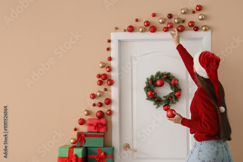 Young woman in Santa hat ha...