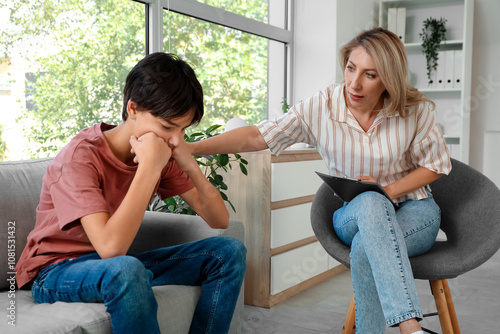 Female psychologist working with upset teenage boy in office
