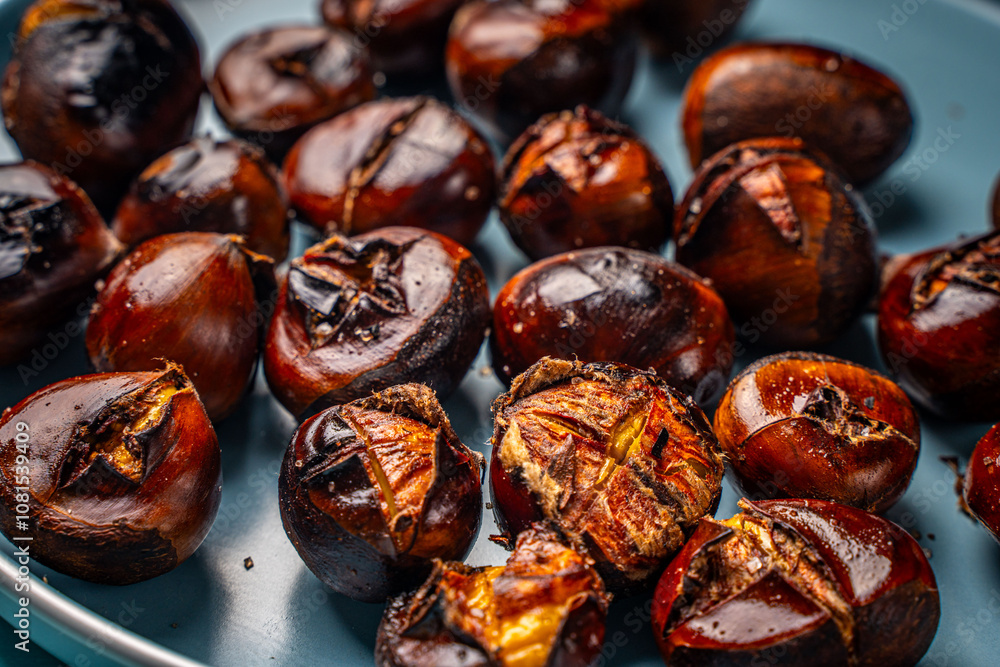 Roasted chestnuts on a blue plate. Close-up. View from above. High quality photo Roasted chestnuts on a blue plate. Close-up. View from above. High quality photo
