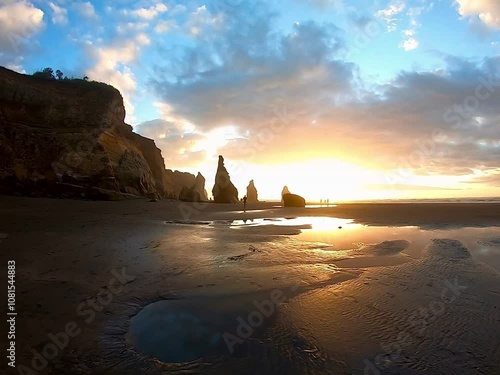 The Three Sisters rock formation at sunset , access at low tide , Tongaporutu beach, Taranaki  photo