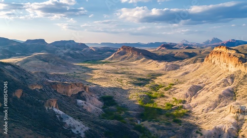 Aerial view of a beautiful desert landscape with dramatic rock formations and blue sky, sunny weather, and clouds