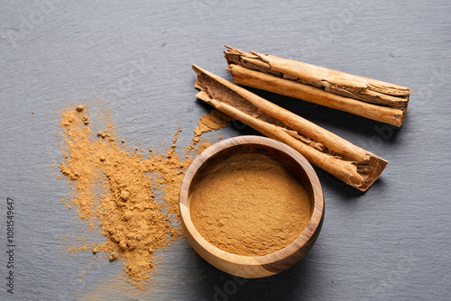 Cinnamon Sticks and Powder on Gray Slate photo