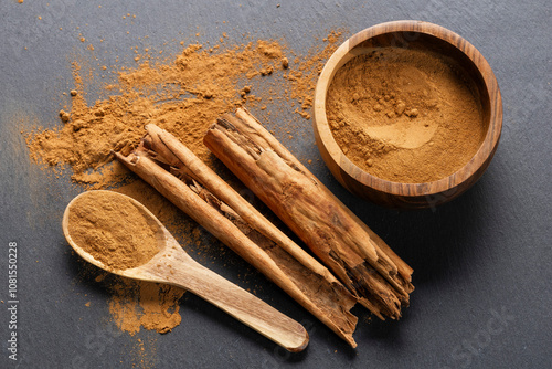 Cinnamon Sticks and Powder on Gray Slate photo