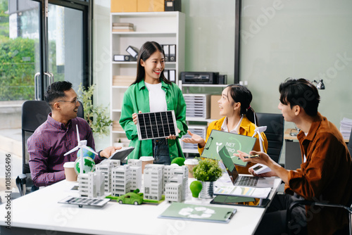 Group of diverse multiethnic businesspeople standing neare table looking at model of building from residential project. Green business company photo