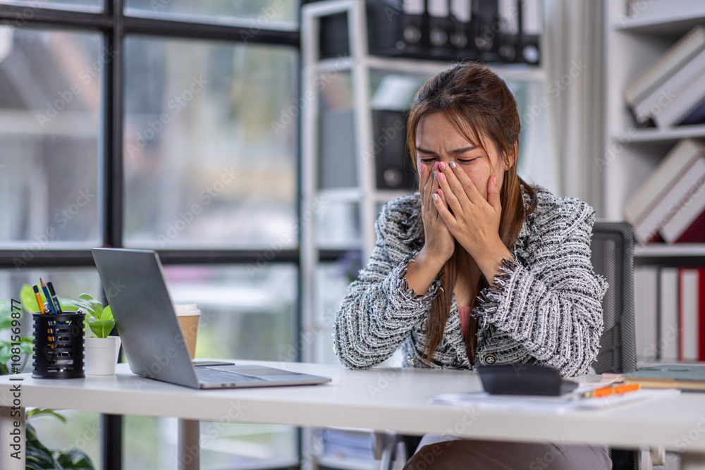 Stressed office worker sitting at desk with laptop feeling burnout. asian woman looking frustrated while working on laptop. Concept of stress, frustration, and burnout in workplace.
Stressed office worker sitting at desk with laptop feeling burnout. asian woman looking frustrated while working on laptop. Concept of stress, frustration, and burnout in workplace.