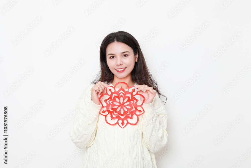 A Chinese woman putting up window decorations at home on the theme of Spring Festival A Chinese woman putting up window decorations at home on the theme of Spring Festival