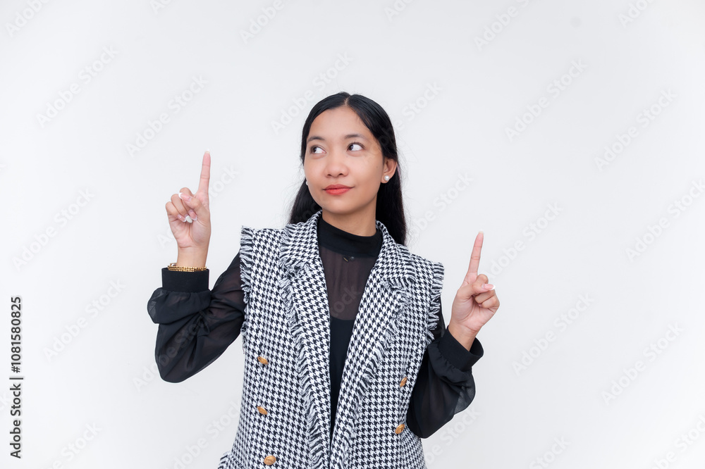 Young woman pointing up in stylish houndstooth vest and sheer blouse Young woman pointing up in stylish houndstooth vest and sheer blouse