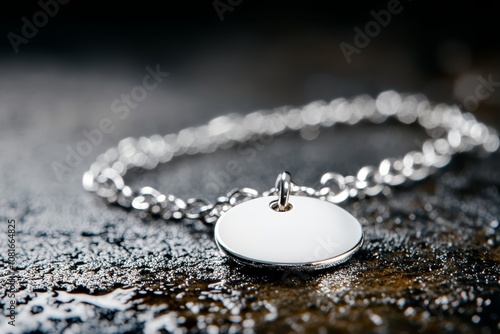 A silver necklace with a white disc on a chain