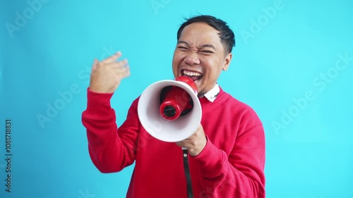 Young Expressive Asian Man Using Megaphone Inviting And Announces Discounts And Sales On Light Blue Background