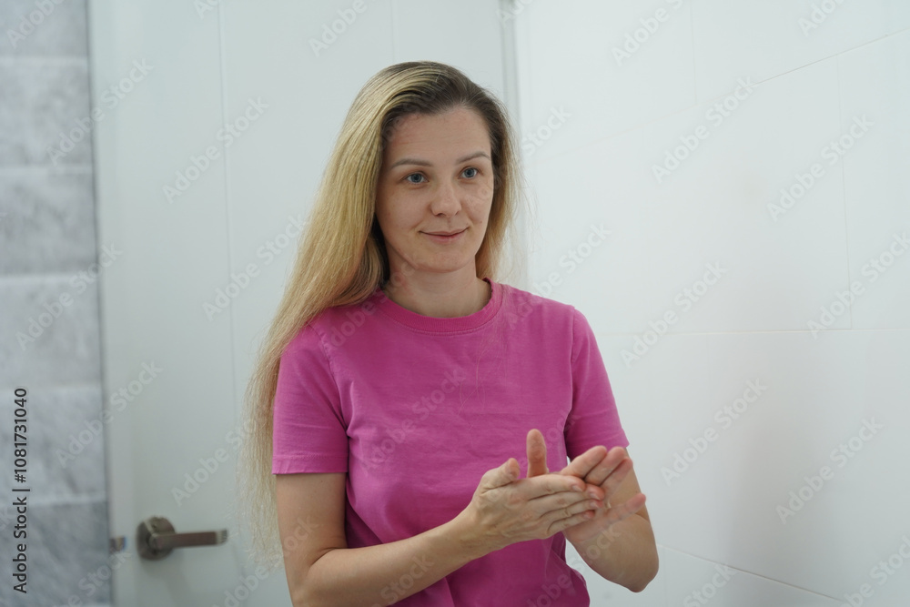A woman is expertly styling her hair using a blow dryer and brush while in the bathroom A woman is expertly styling her hair using a blow dryer and brush while in the bathroom