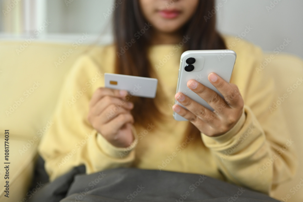 Young woman holding a credit card for online shopping or using mobile banking Young woman holding a credit card for online shopping or using mobile banking