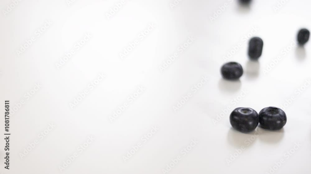 Blueberries Rolling Down on White Background Blueberries Rolling Down on White Background