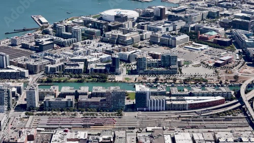 Aerial view of the Caltrain station in San Franciscos Mission Bay area, featuring parked trains, adjacent residential buildings, and the nearby canal. photo