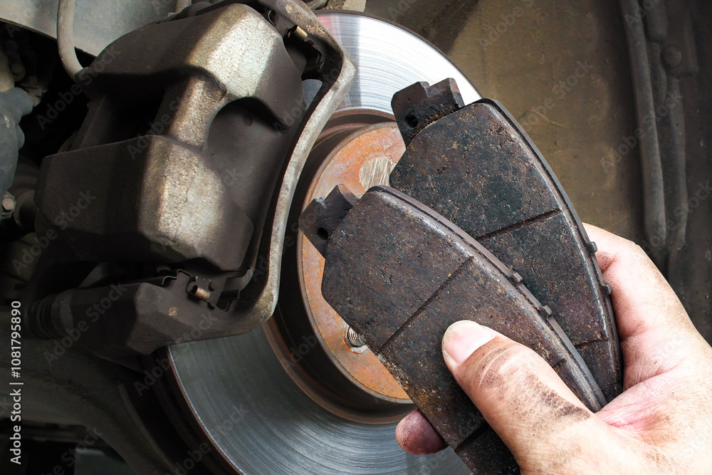 Auto mechanics replace worn brake pads to maintain a car braking system , Car maintenance concept
