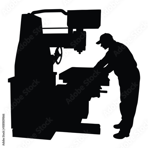 A man is working on a machine. The machine is black and has a large wheel. The man is wearing a hat