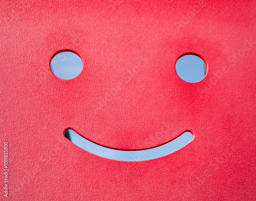 A red emoticon is smiling on the playground. A smiley emoticon will improve your mood. photo