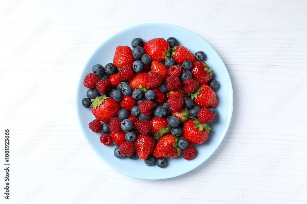 Different fresh ripe berries in bowl on the table, top view Different fresh ripe berries in bowl on the table, top view