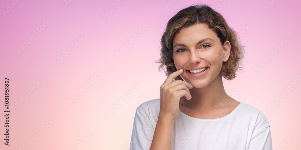 A smiling woman touches her chin with a finger against a pink gradient background. This high-quality stock photo is perfect for concepts of contemplation, positivity, and thoughtful moments in A smiling woman touches her chin with a finger against a pink gradient background. This high-quality stock photo is perfect for concepts of contemplation, positivity, and thoughtful moments in