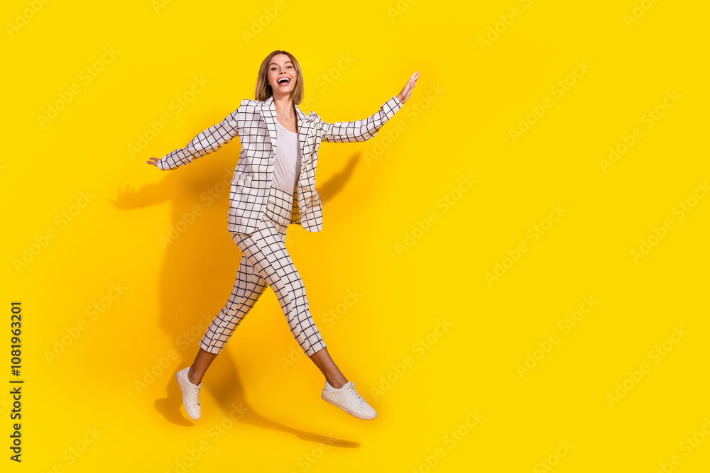 Full body photo of attractive young woman running jump excited dressed stylish white plaid clothes isolated on yellow color background Full body photo of attractive young woman running jump excited dressed stylish white plaid clothes isolated on yellow color background