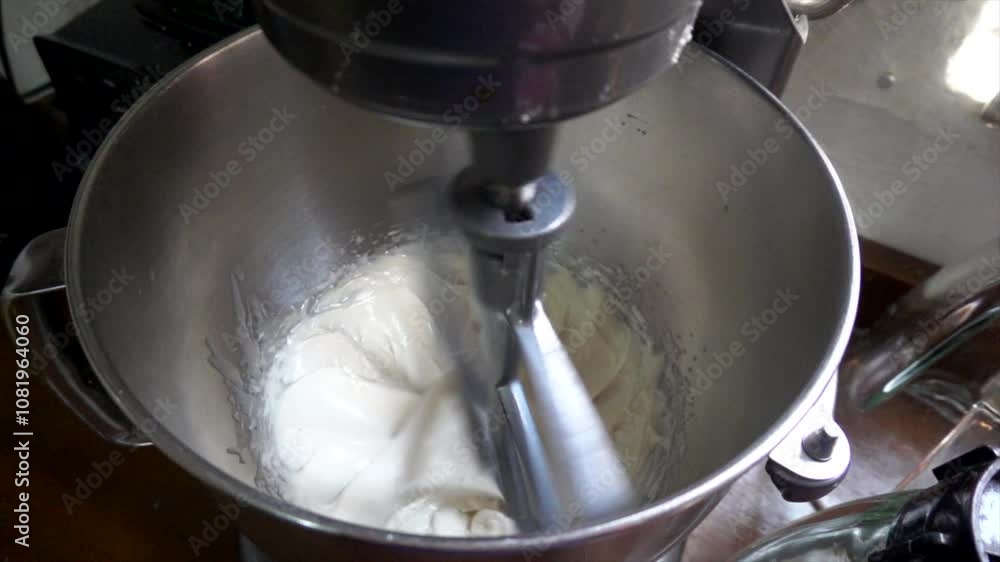 Metal stand mixer whisking ingredients in a stainless steel bowl creates a delightful blend for baking and cooking Metal stand mixer whisking ingredients in a stainless steel bowl creates a delightful blend for baking and cooking