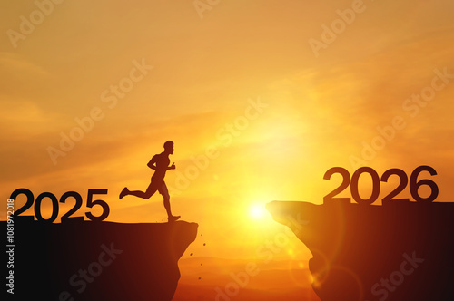 New Year 2026, Inspiration and progress towards new success. Silhouettes of human jumping over cliff towards finish line with text new year 2026 on sunset beautiful