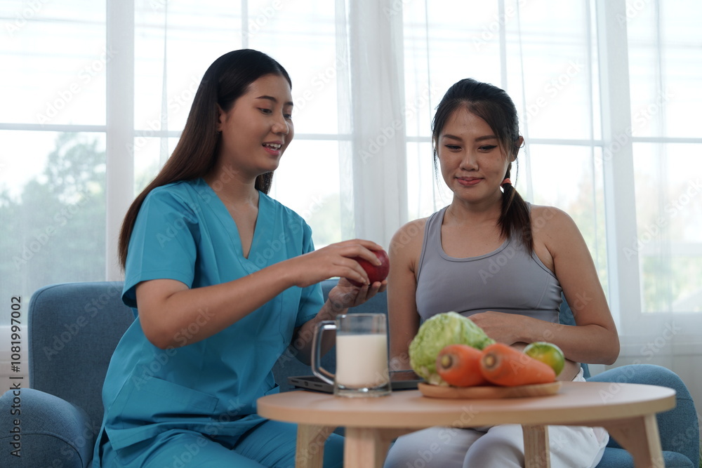 Asian nurse nutritionist holding tablet recommends fruit and milk food to pregnant Asian mothers. Food is nutritious for the baby in the womb.