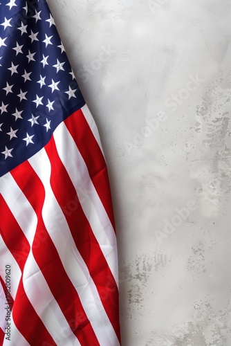 A partial view of the American flag displaying the blue field with white stars and red and white stripes in a textured fabric design set against a rough white surface with copy space.