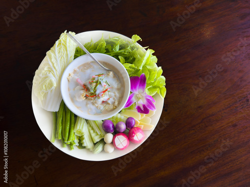 Salted Crab in Dipping Sauce with eggplant, lettuce, green beans, cucumber and Paco Fern on a white plate.Photo with clipping path.