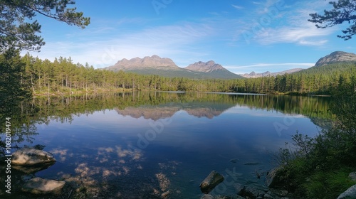 A serene lake surrounded by dense forest, with the reflection of mountains mirrored on the water.