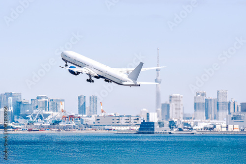 東京の空、スカイツリーを背景に大都会を飛ぶ飛行機