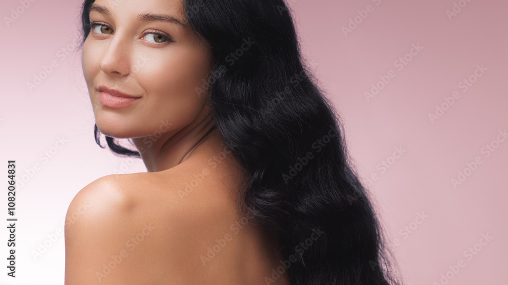 A stunning woman with long black hair smiles over her shoulder, showcasing her smooth skin against a soft pink background. Ideal for beauty, skincare, and wellness themes. A stunning woman with long black hair smiles over her shoulder, showcasing her smooth skin against a soft pink background. Ideal for beauty, skincare, and wellness themes.