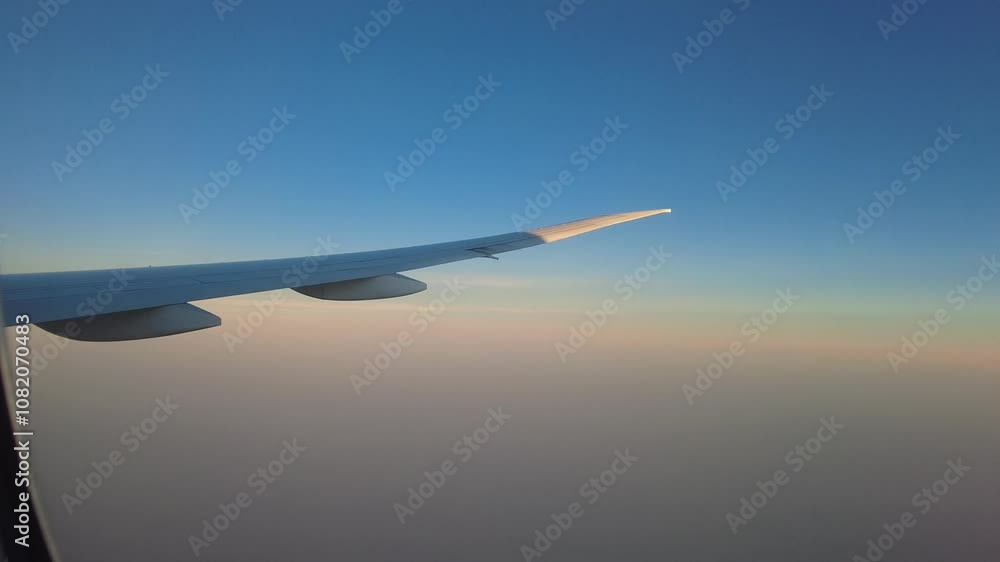 Airplane in flight, reveal of the peaceful side window view of sunrise Airplane in flight, reveal of the peaceful side window view of sunrise