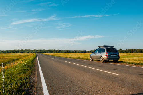 the car is parked on the side of the road at sunset in the evening