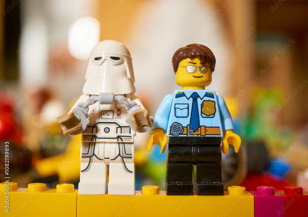 Obraz premium Lego brand Star Wars Snowtrooper and a police officer toy figurines on a blurred background