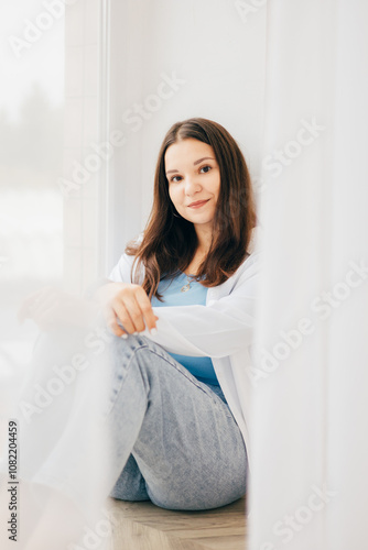 A woman in a white shirt and jeans showing a stylish and understated look. The light background and natural pose give the shot a modern feel. Free Download A woman in a white shirt and jeans showing a stylish and understated look. The light background and natural pose give the shot a modern feel. - GFXLoad