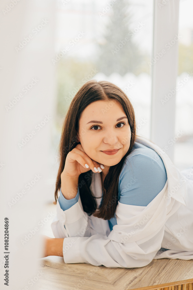 girl leaning against the wall, smiling, light portrait