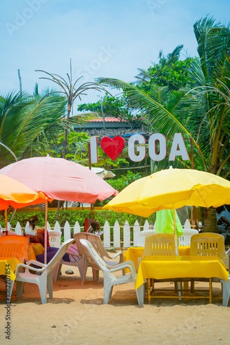 beach side shacks during day with I love Goa sign, umbrellas and chairs for tourists to sit and enjoy food drinks on vagator, anjuna, calangute beach photo