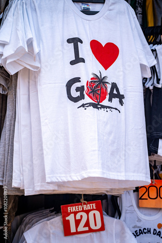 White shirts with I love Goa hanging in a shop ready for sale, cheap quick dry beach wear people buy for photogaphy photo