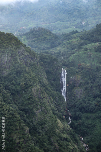 A Picturesque locale of the Nilgiris hill range in Western Ghats with a Waterfall flowing majestically and the clouds moving above in India. photo