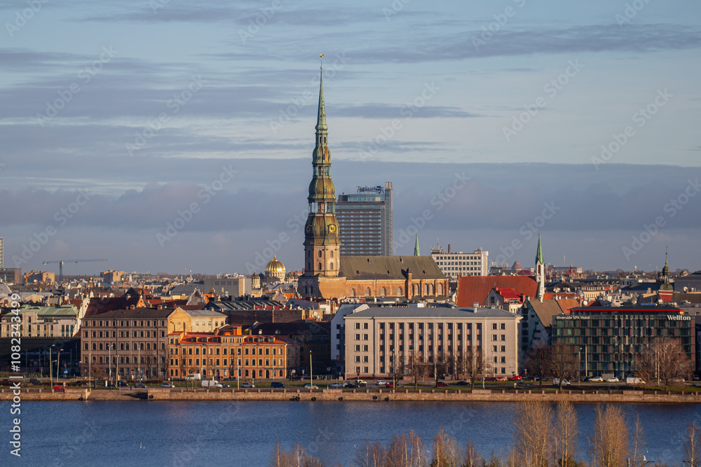 Fototapeta premium Riga, Latvia city skyline in late 2024 with could and warm light of river Daugava and buildings in city center and old town 