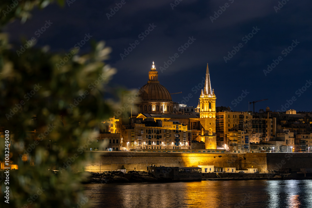 Obraz premium Valletta, Malta A night view of the skyline of the old town of Valletta, Ball's Bastion, and the Cathedral dome.