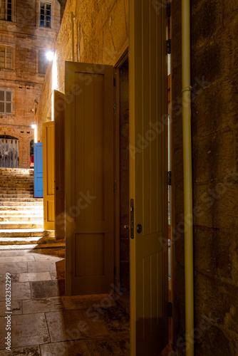 Valletta, MaltaA batch of open doors on an old stone street at night. photo